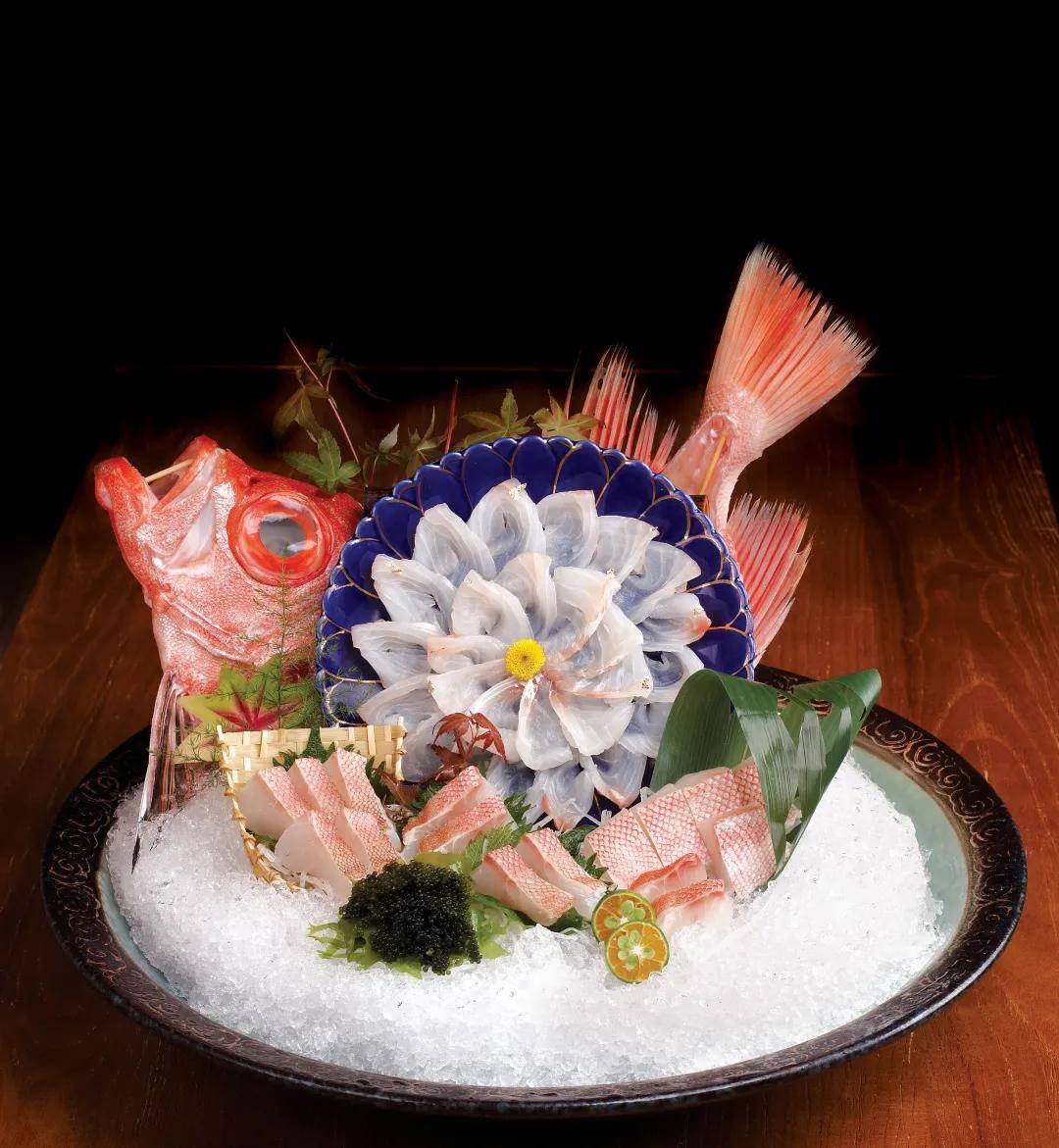 大师手起刀落间一片片晶莹剔透的生鱼片还原一条栩栩如生的"大眼鸡""