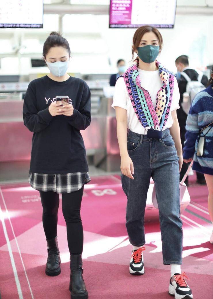 卫衣 Twins合体走机场，一个穿短袖一个穿两件长衫+皮靴，仿佛两个季节