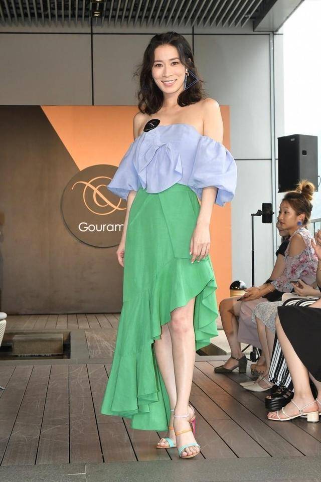 进行 佘诗曼气质开挂，身穿浅蓝色一字肩上衣身穿高筒靴，减龄又时髦