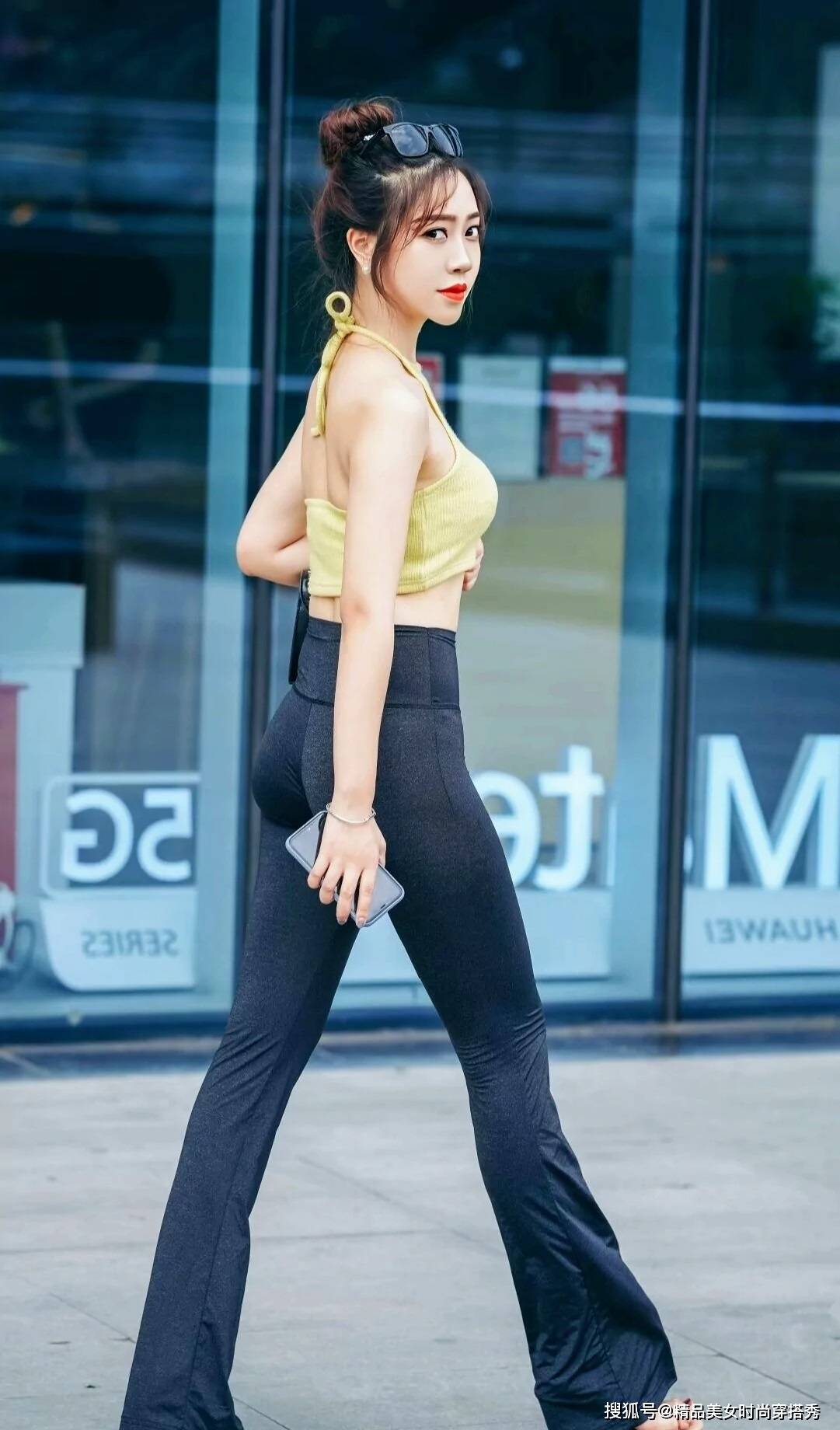 个性 黄色的挂脖背心清凉吸睛,下搭一条黑色的紧身喇叭裤,休闲又性感