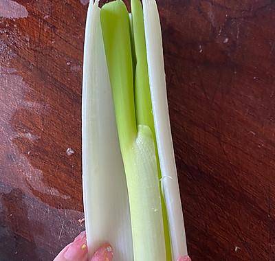 7,再来做个凉拌葱丝: 大葱剖开后,取出中间的葱心;8,葱白折叠起来切丝