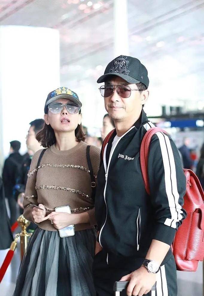 黑色 郭晓东夫妇走机场，42岁程丽莎一身夸张纱裙公主风，老公太接地气