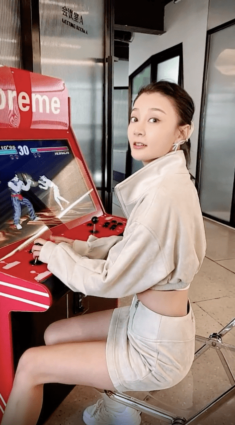 随后,唐菀与游戏机合影,并站起来拍照以突出完美身材的比例.