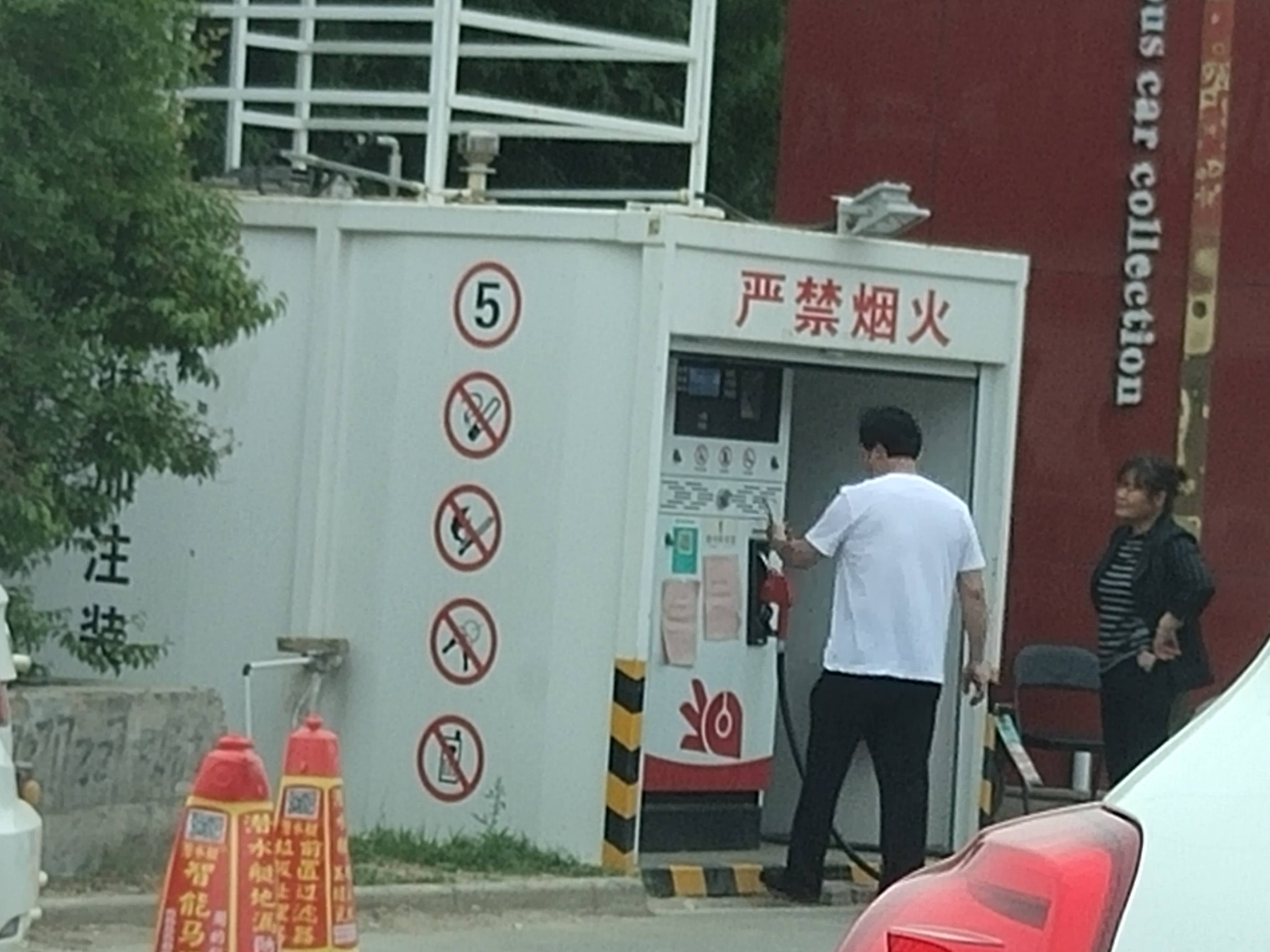 一个白色铁皮箱加油站,其约有4米长,2米宽,2米高,箱体上印有"严禁烟火