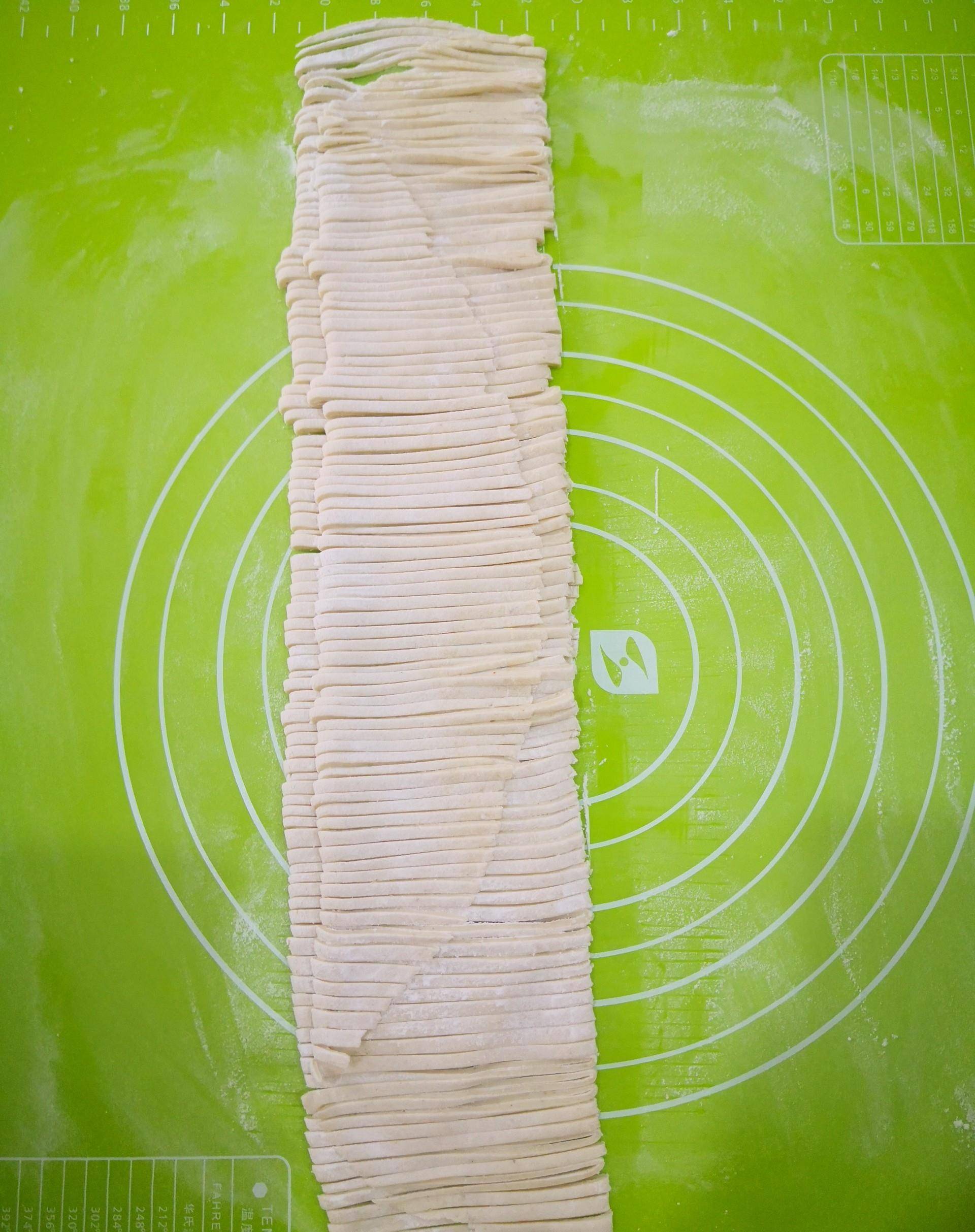 面片上均匀地撒上一层薄面粉,防止粘黏,再把面片叠起来.