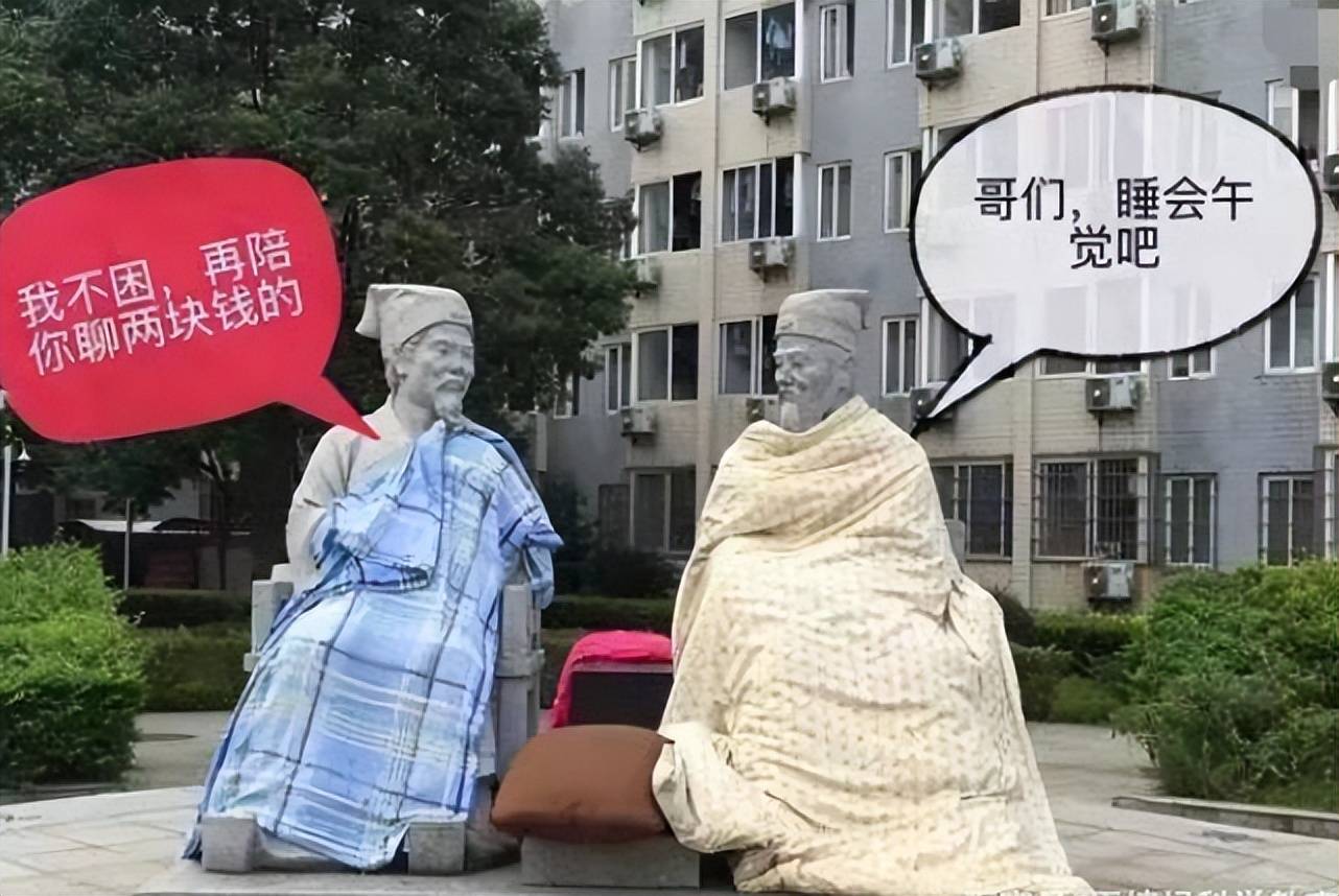 两个雕像腿上盖着棉被,一个雕像手中还拿着羽扇,就好像是在聊天一样
