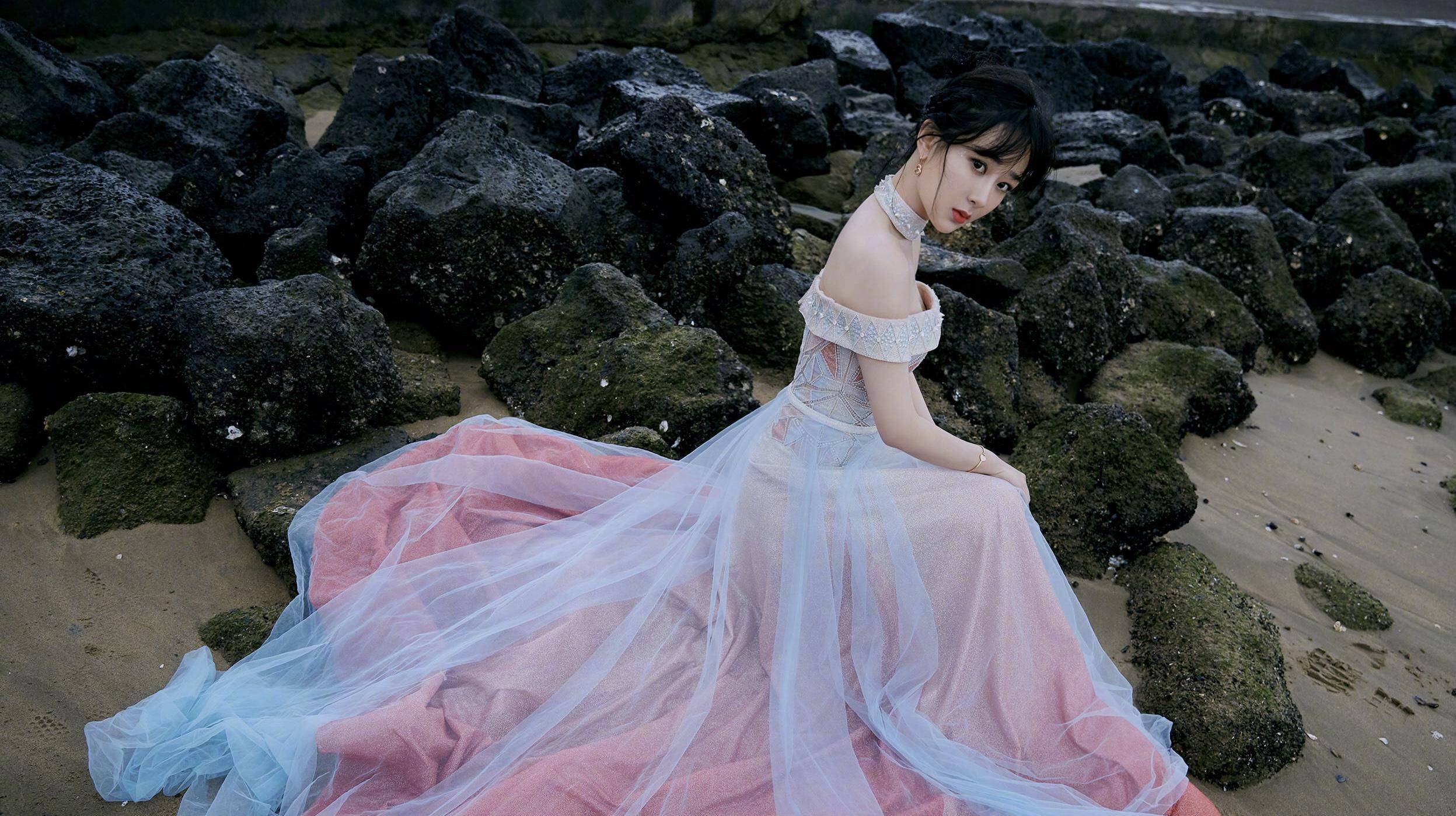 现身海边的杨紫,身穿了一条彩色礼服裙装,露肩的设计把天鹅颈与锁骨