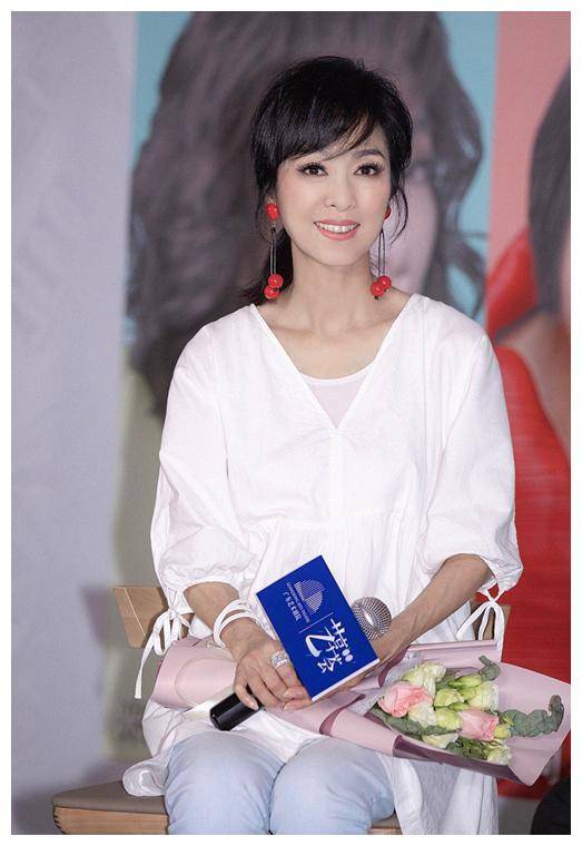 原创米雪身穿白色v领上衣现活动红色耳环很减龄63岁还像小姑娘