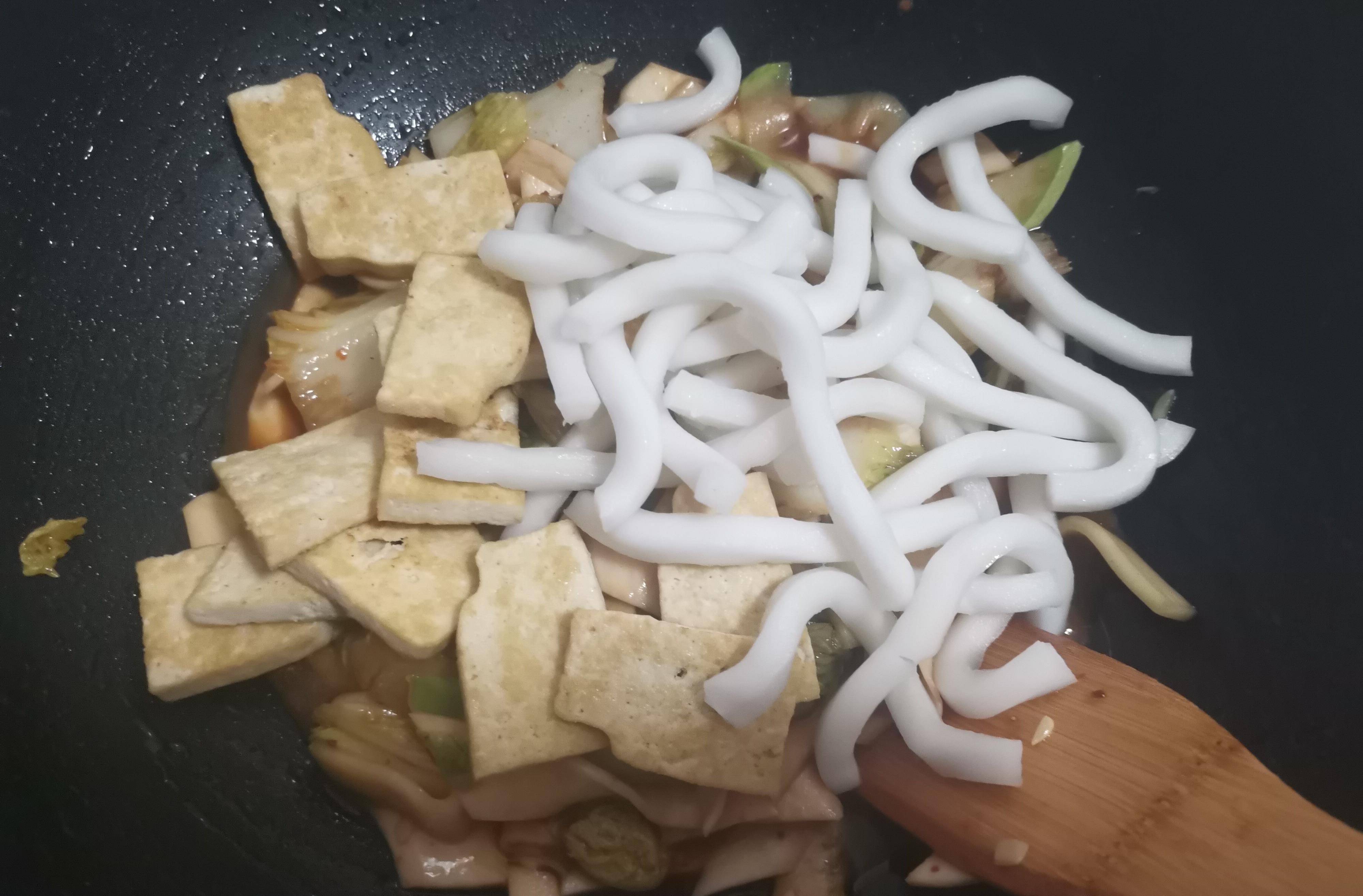 6,煸炒均匀后放入煎好的豆腐,以及手擀粉翻炒,稍微多炒一会,一来让