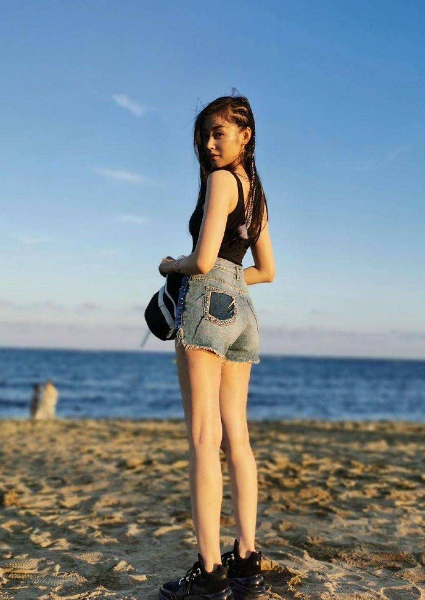 明星写真:张天爱吊带背心牛仔短裤海滩时尚美拍,修长美腿抢镜_爱的