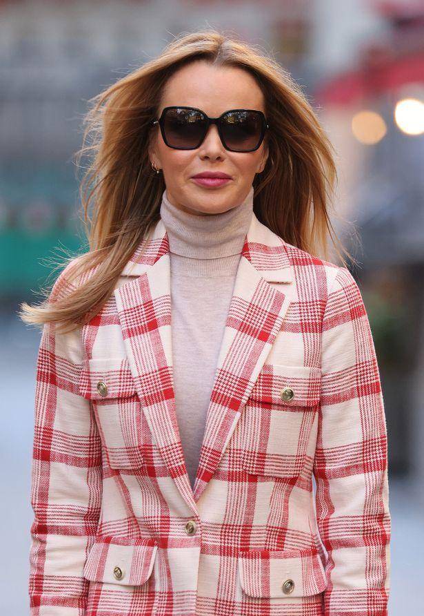 51 岁的阿曼达·霍尔登 穿着粉红色迷你裙 及膝高跟鞋,露出色调别针