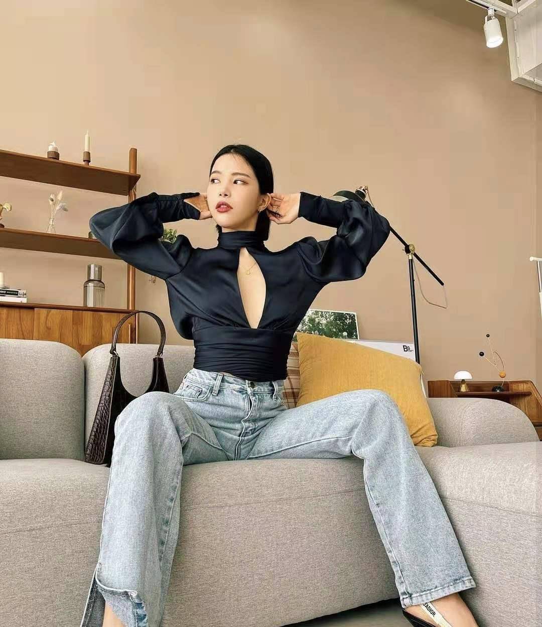 照片中,颂乐身穿裁剪别致的黑色丝绸上衣,搭配浅色牛仔裤,一身装扮酷