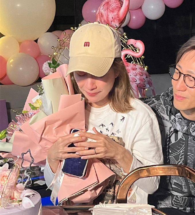 "生日之星"邝文珣身穿白色t恤,头戴棒球帽,中长发染得凌乱,衣着简单