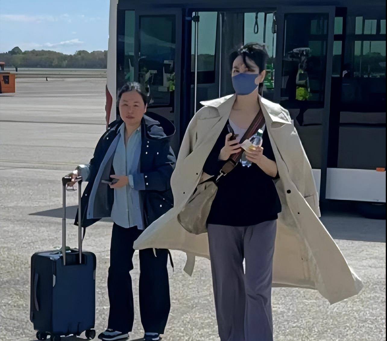 53岁王菲穿着宽松现身机场,小腹凸起引热议,网友:不会怀孕了吧_李嫣