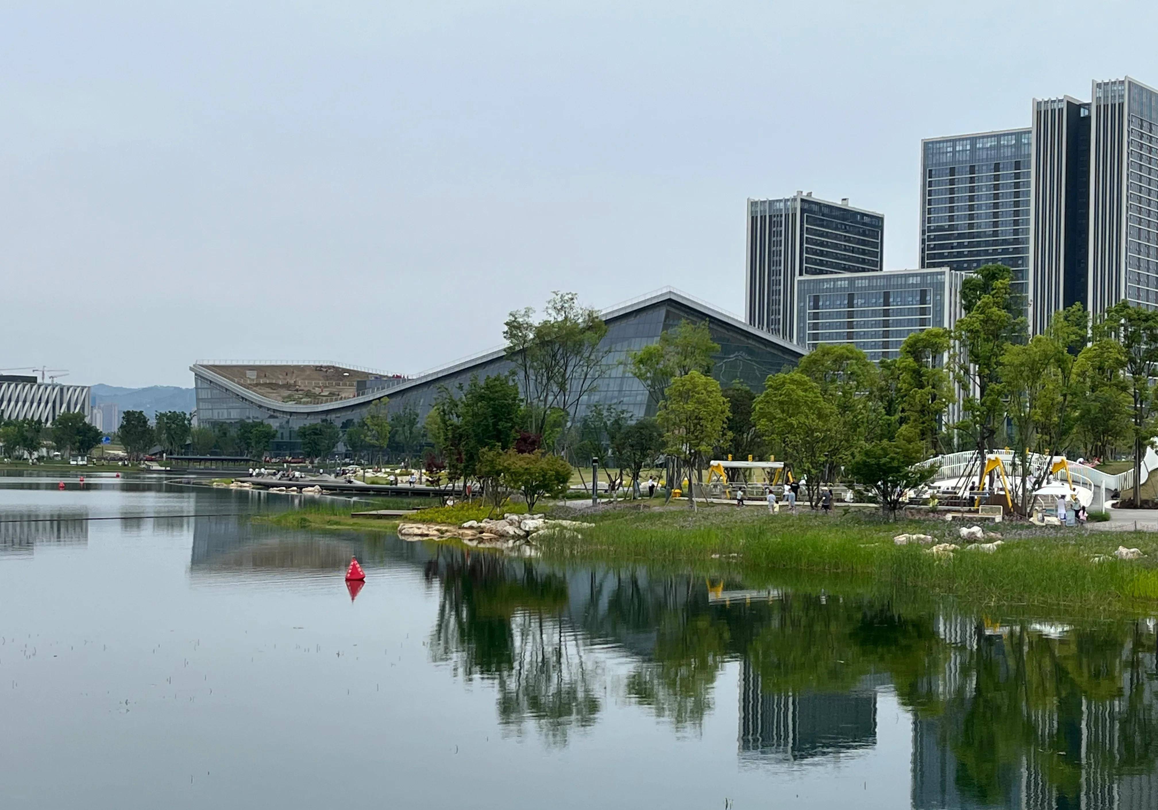 公园一角像火炬图标的建筑物远眺湖对面的主场会馆东安湖公园一角矗立