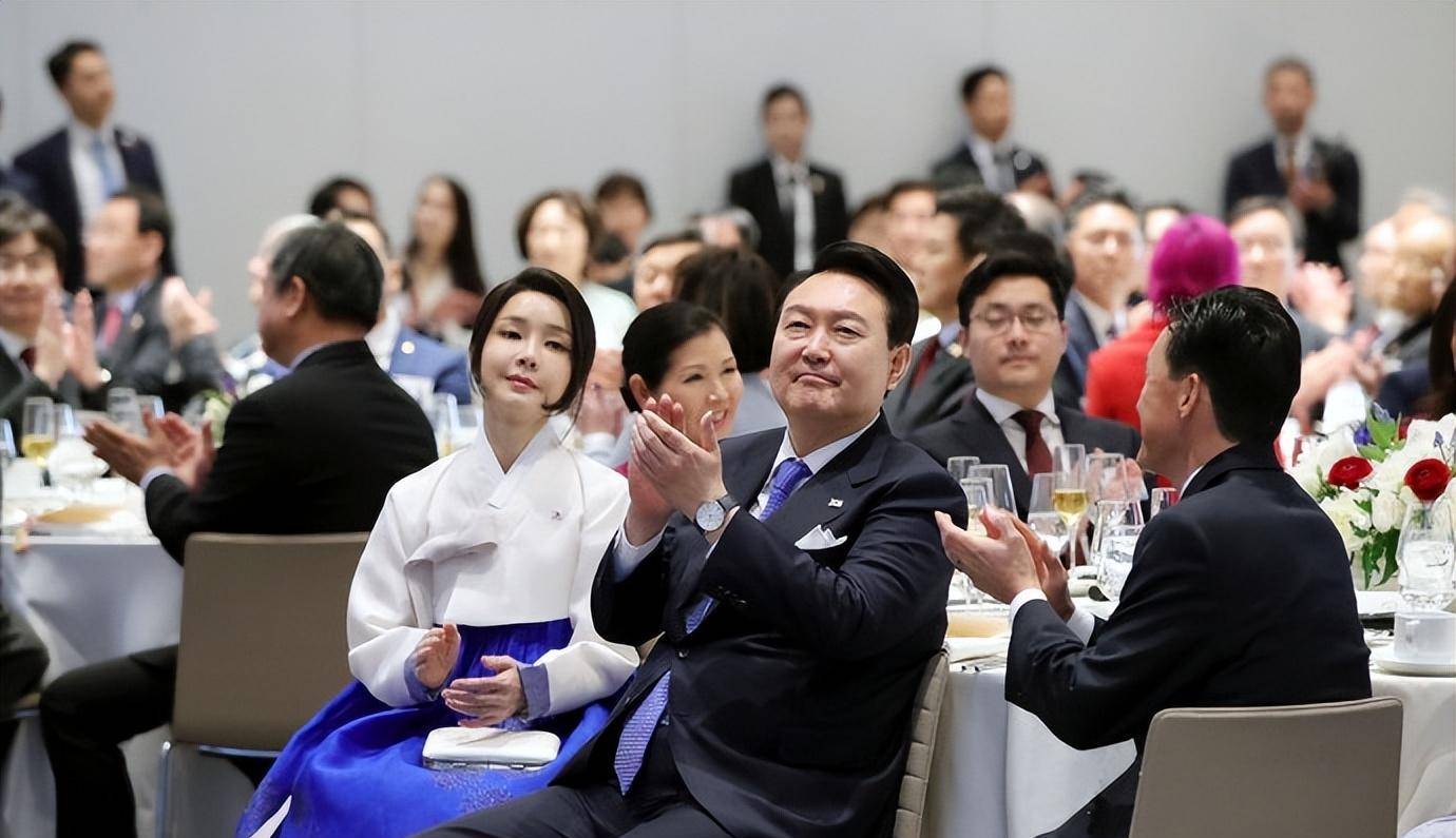 虽然她的裙子也呼应了她老公的蓝色领带,但是她的这个发型真的比披散