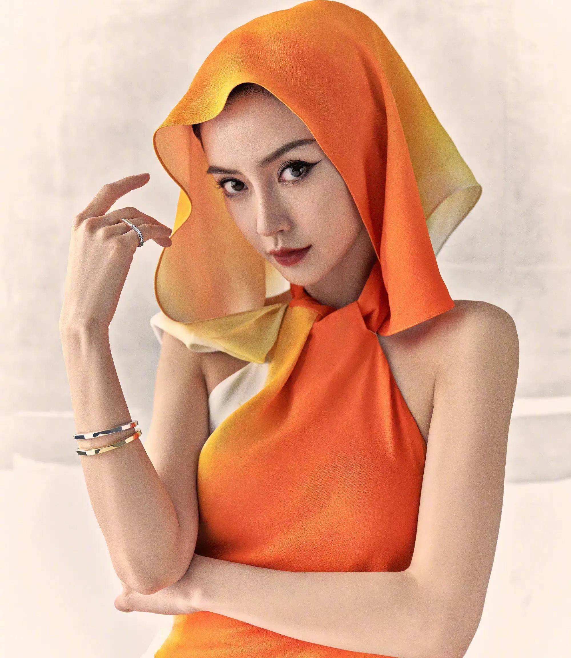 杨颖在杂志封面上还穿着一身迷彩装,搭配白色和橙色的帽子,设计了两种