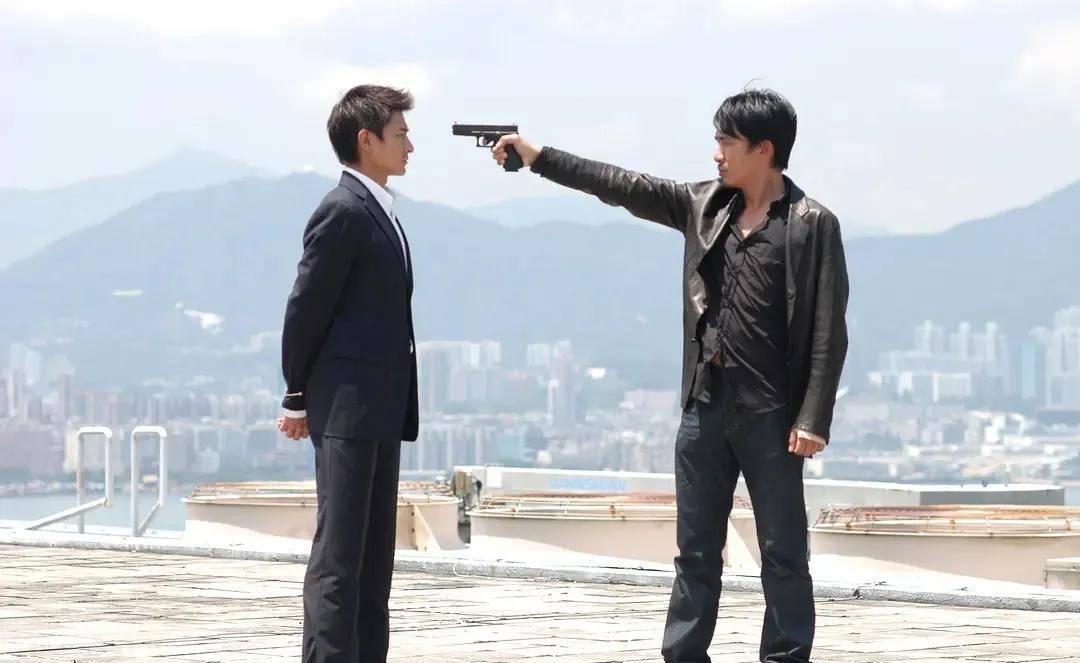 梁朝伟一只手持枪,枪口对准了刘德华的印堂穴.