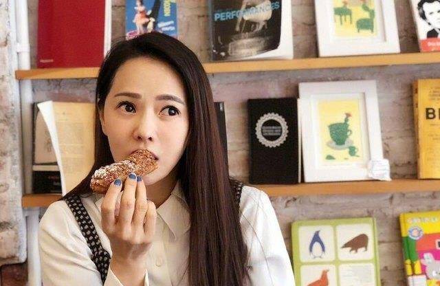 伊能静手里拿着面包,眼睛望着窗外,表情确实很搞笑,小哈利这张照片抓