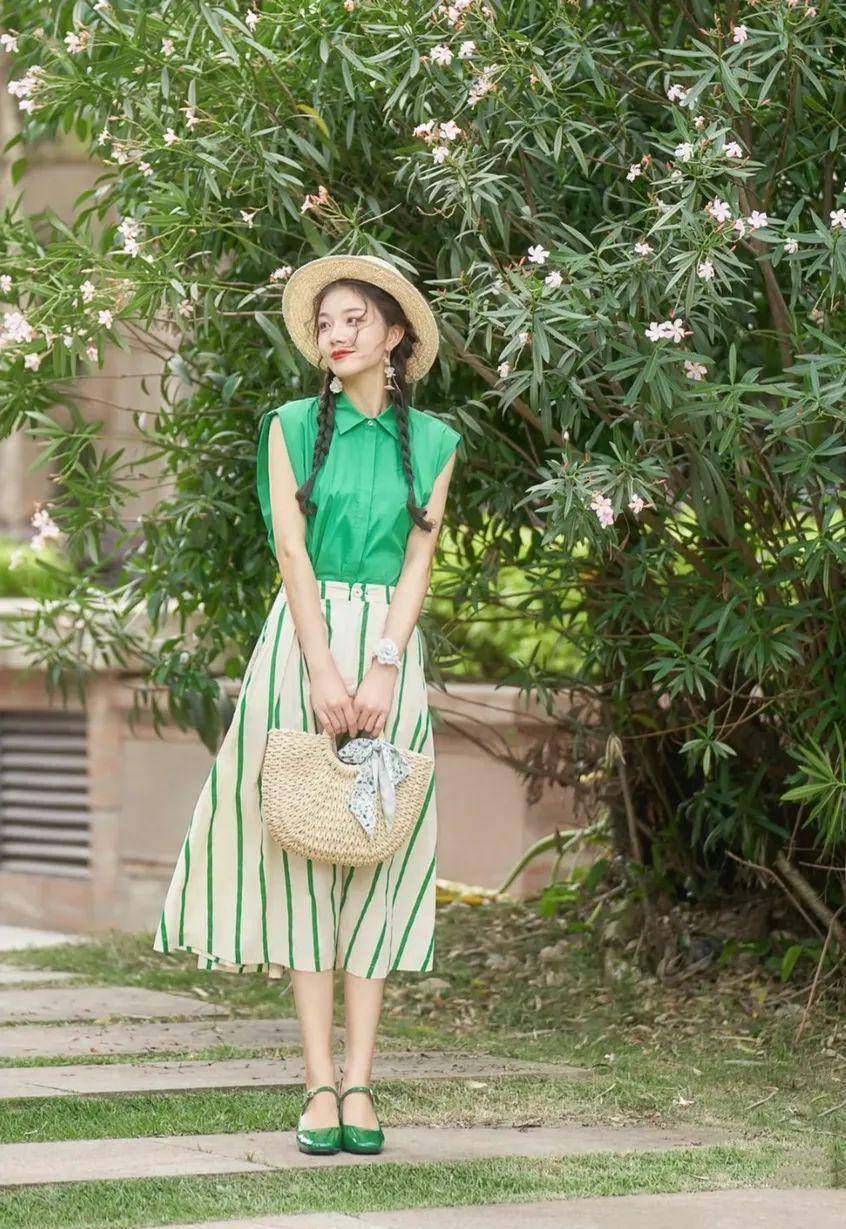墨绿色无袖衬衫搭配百褶裙和绿色玛丽珍鞋打造出优雅的一字肩造型