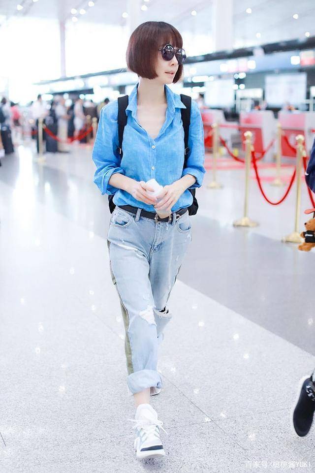 也是鲁豫的一次机场街拍,她上身是一件牛仔衬衫,领口处随意地解开了两