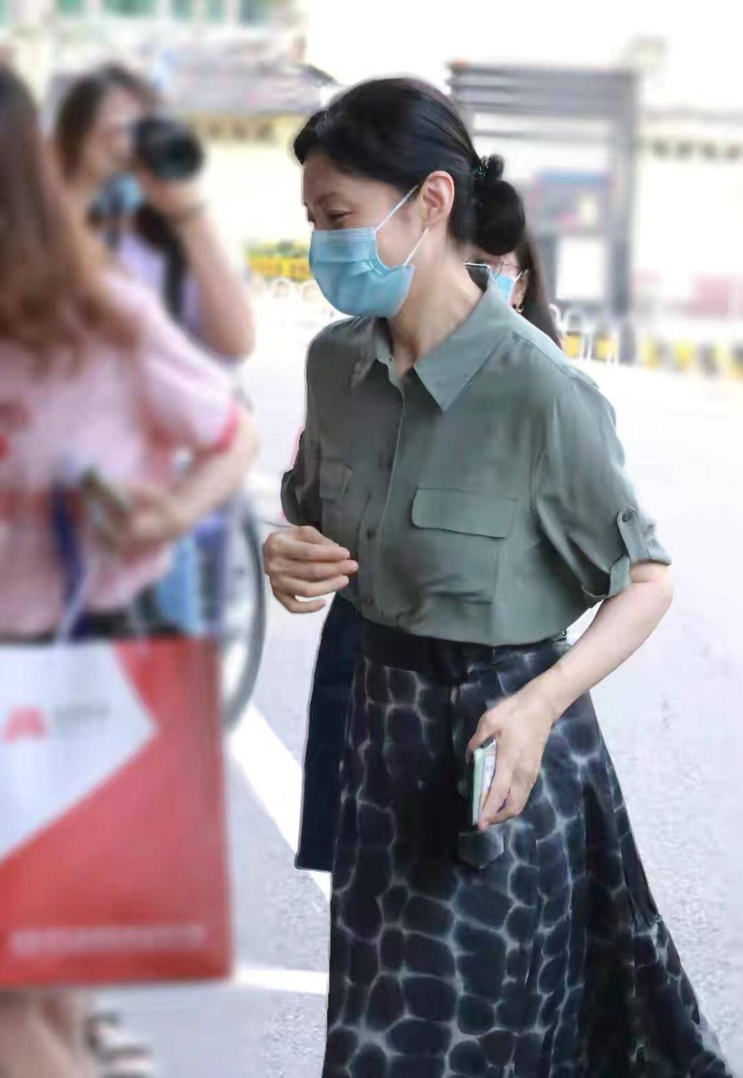 他穿着一件白色衬衫,里面是蓝色时尚衬衫和蓝色牛仔裤.