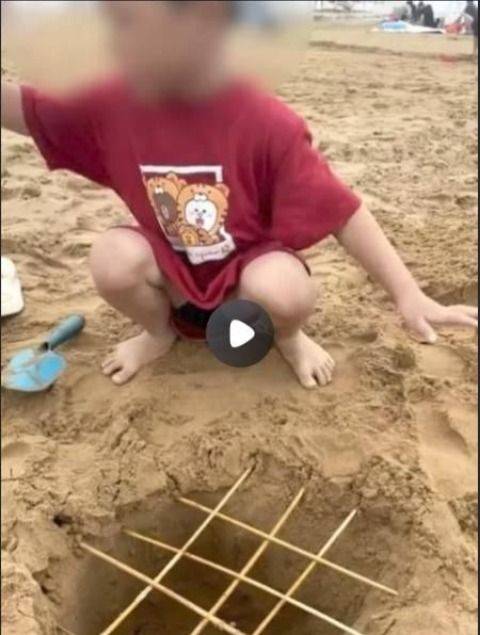 母亲晒孩子在沙滩制竹签陷阱引争议 青岛金沙滩上恶作剧始末
