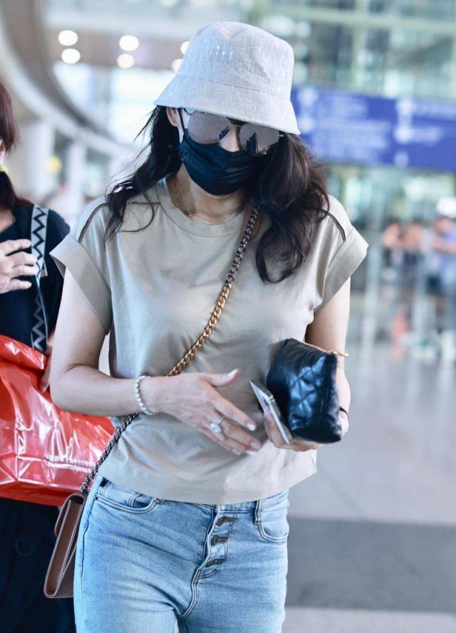 章子怡穿着t恤走向机场.他看起来真的很瘦.下半身搭配牛仔裤.