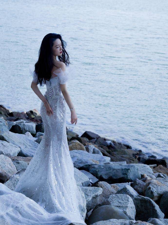 李沁身着串珠人鱼裙,展现姣好的身材,秀发被海风吹起,优雅动人