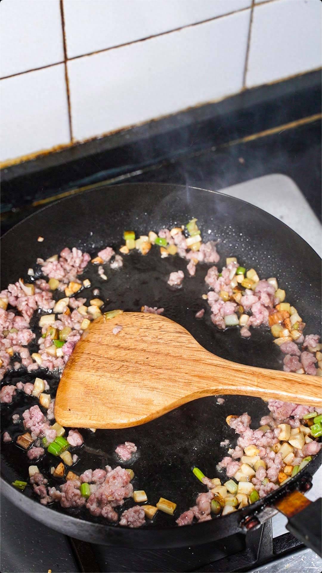 翻炒至肉沫颜色变深,把刚才切好的梅干菜也下入锅中.