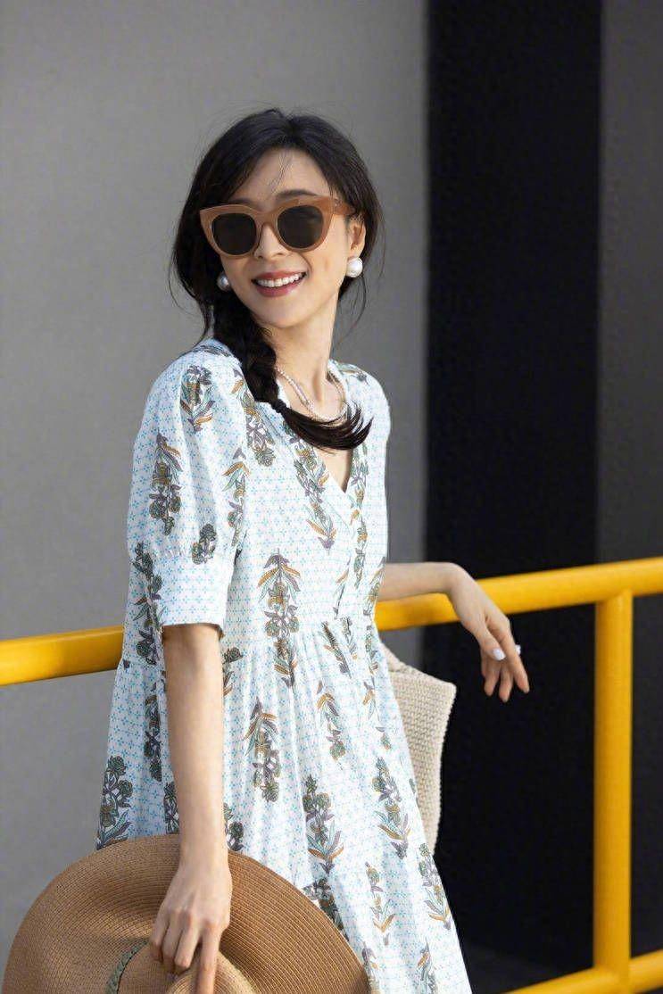 照片中张静初身穿花朵图案连衣裙,散发着灿烂的笑容,尽显她优雅的性格