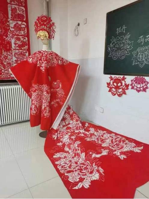 剪纸服装最为震撼,用布剪出镂空图案,做成衣服,云肩,披肩搭民族风旗袍