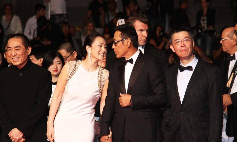 巩俐和陈道明身着优雅的白色礼服,手牵手走上红地毯,张艺谋无奈一笑