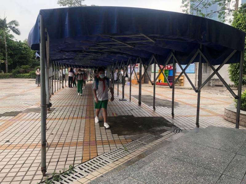 坑口小学校门外,安保人员在分流和疏散家长,校门口不能出现人群聚集