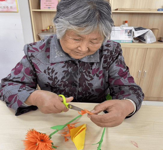 开展"指尖生花 邻里一家亲"——手工制作康乃馨活动_老人