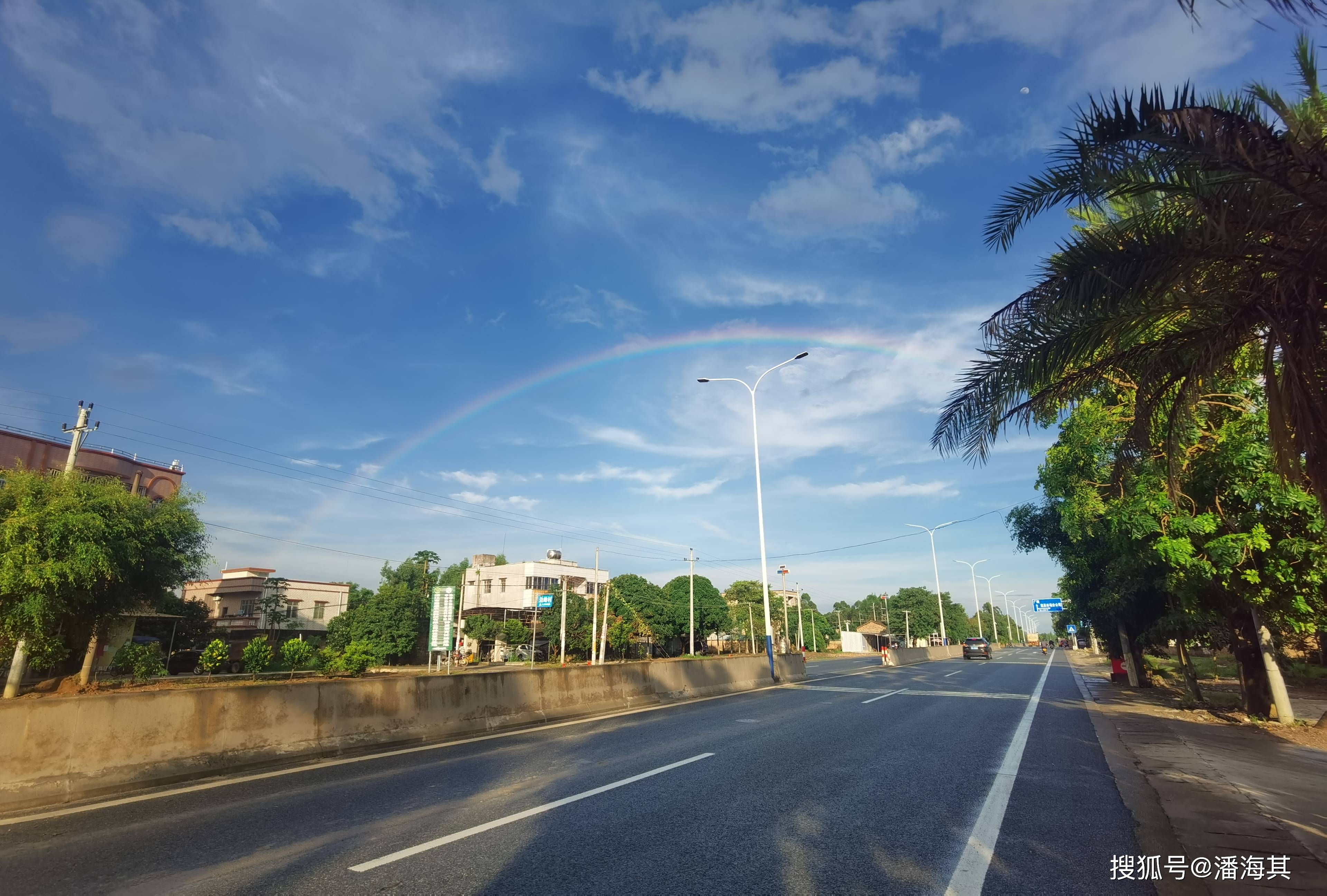 遂溪段的天空上空,出现一道亮丽的七色彩虹,慢慢地横跨过公路另一侧