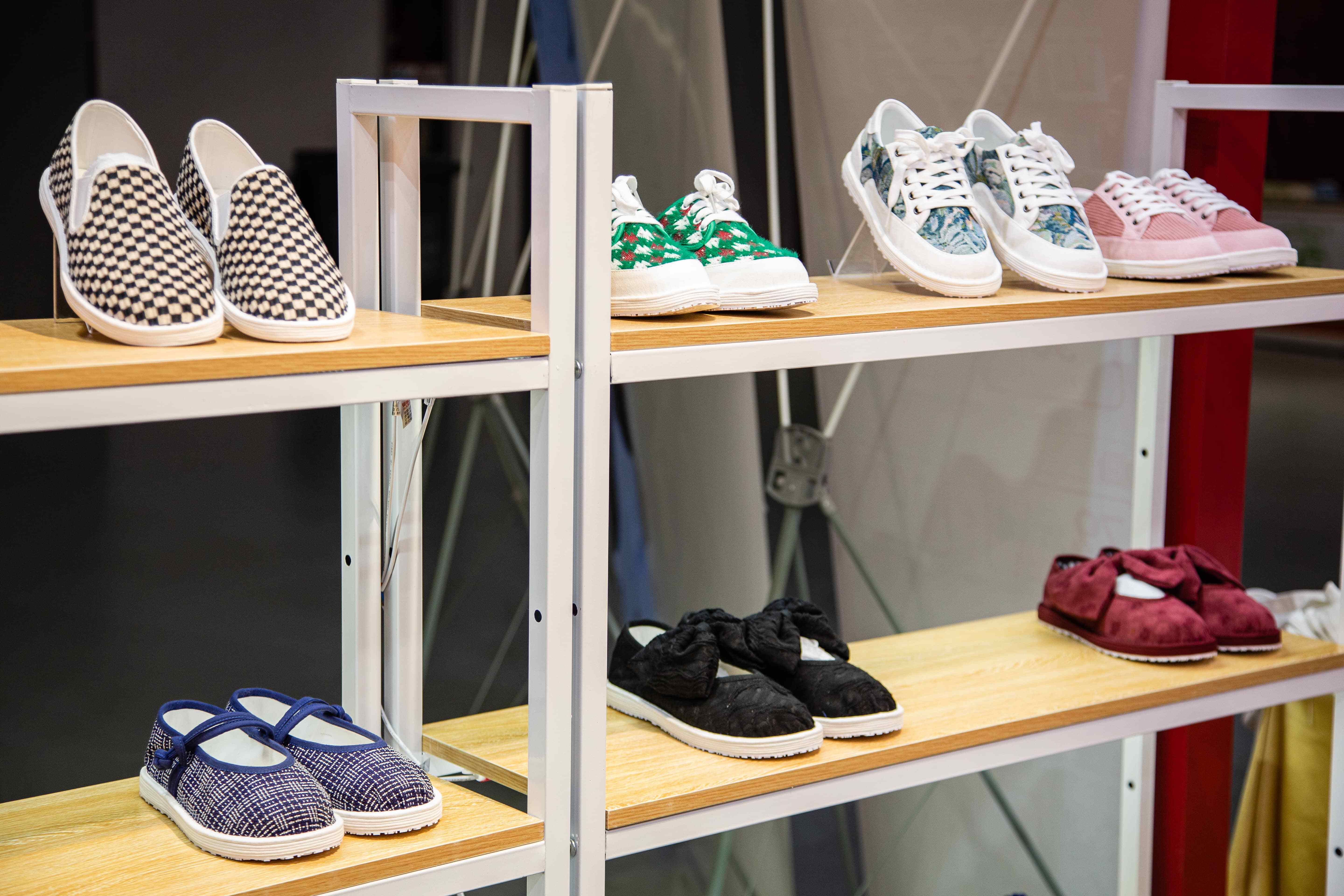 展台参观布鞋的游客,边福茂工作人员都会一一上前,为其详细讲解鞋子的