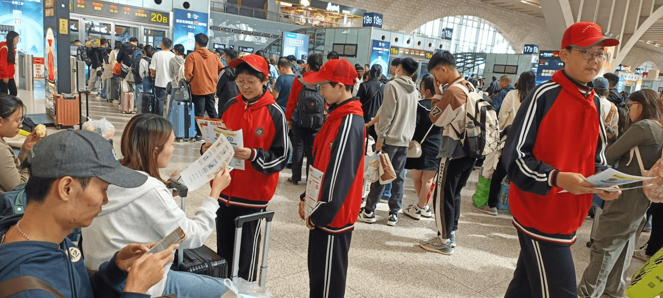 三中学的20名同学身着统一的校服,佩戴志愿者小红帽来到石家庄火车站