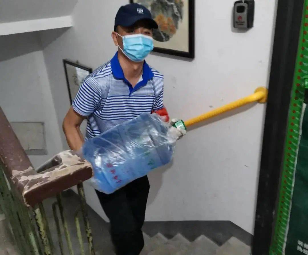社区工作者为居家观察居民代购桶装水并送上门社区工作人员为居家观察