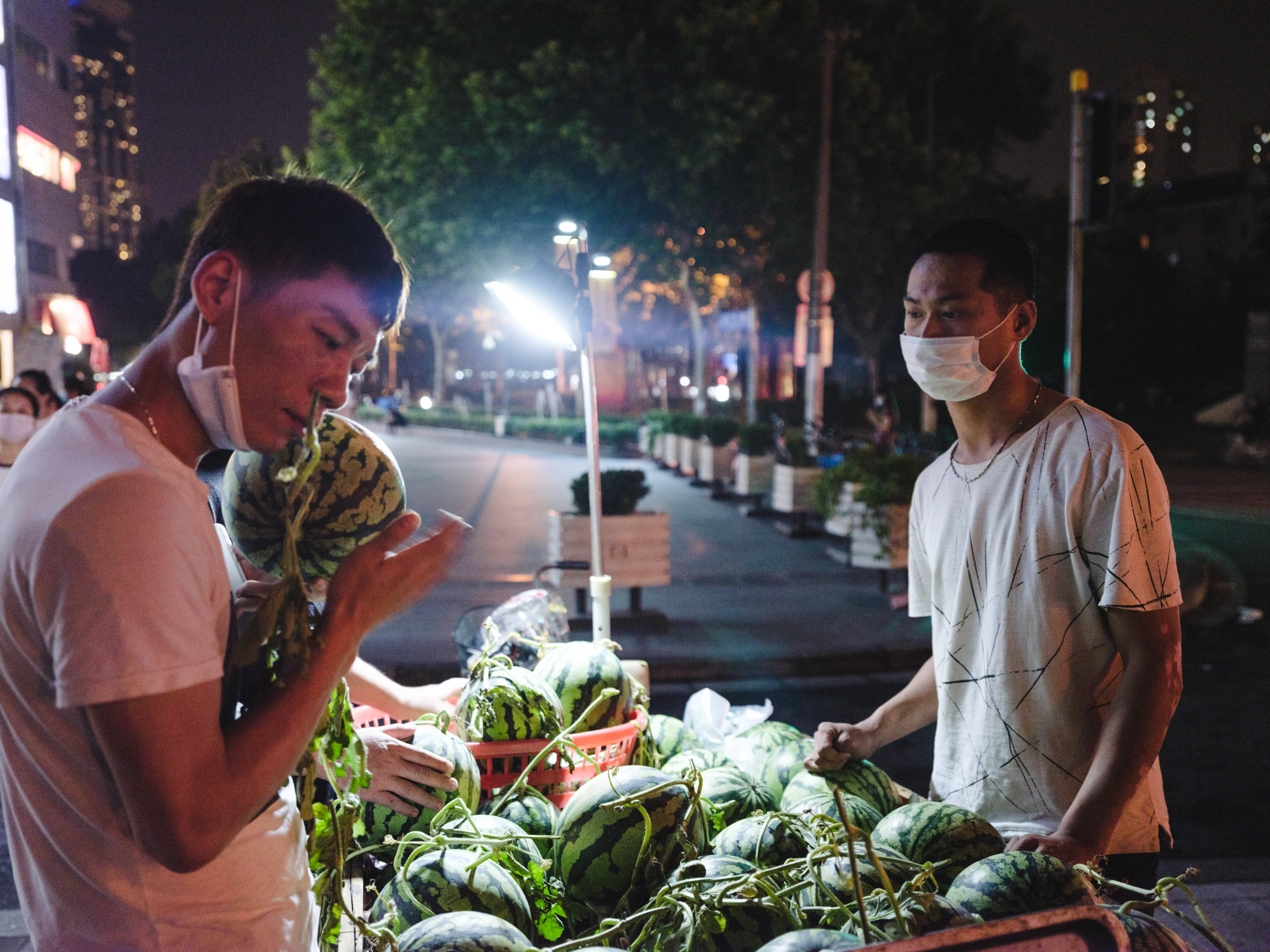 6月3日,蓝村路地铁站外,顾客在三轮车运载的西瓜摊前挑选.