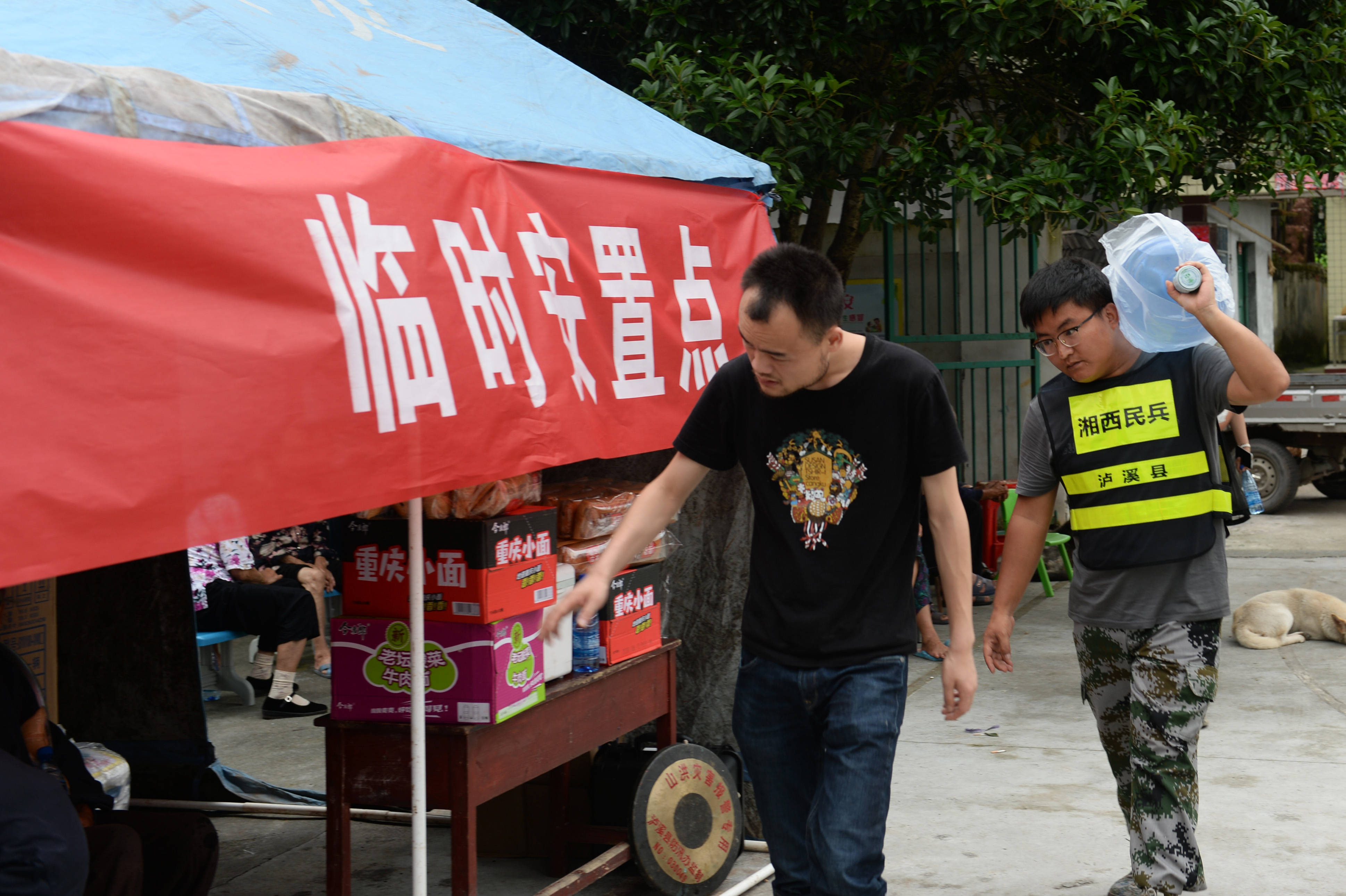 7月10日,在泸溪县解放岩乡临时安置点,工作人员在搬运物资.