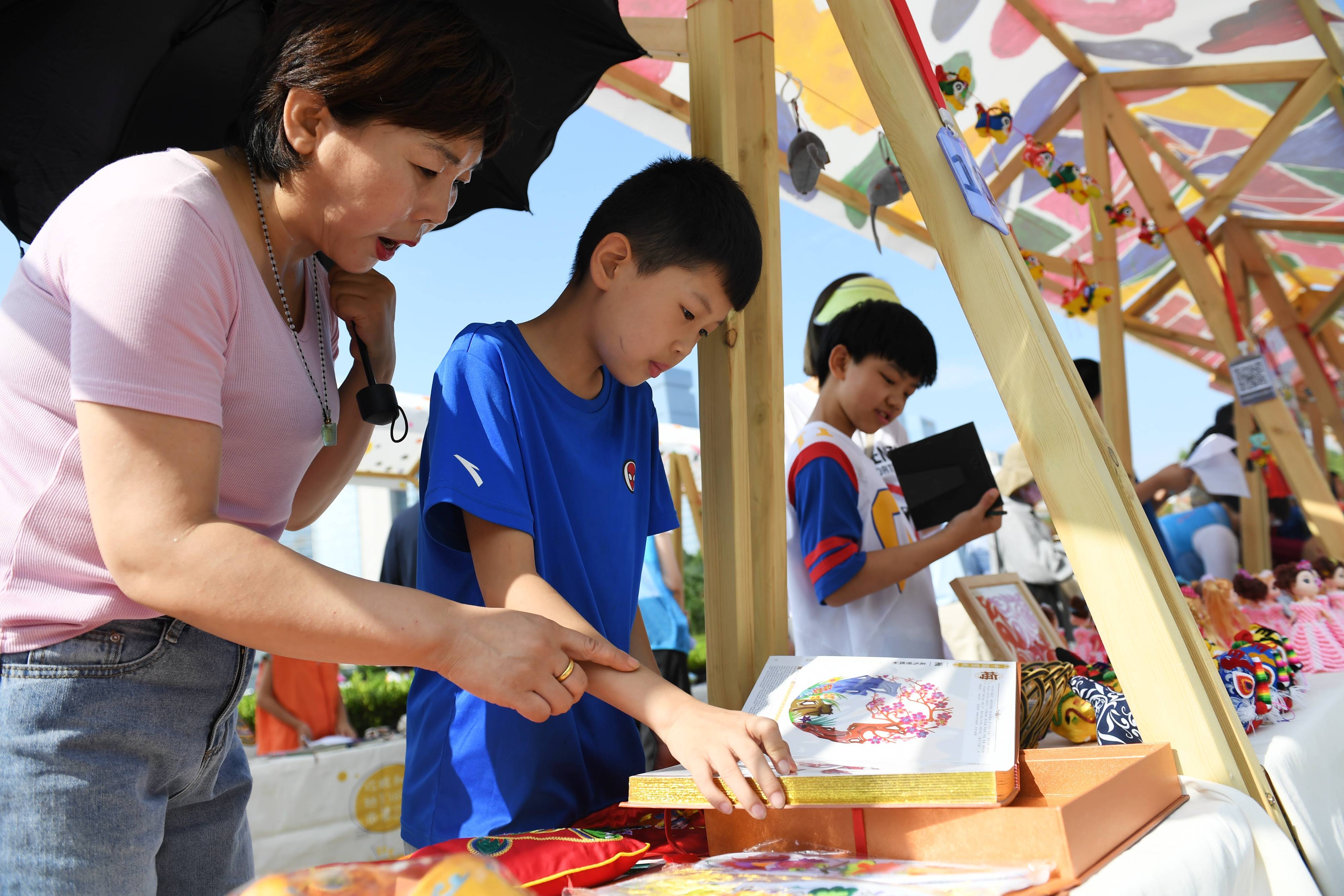 7月30日,在陕西省妇女儿童活动中心,学生小小志愿者在"巧娘和她们的市