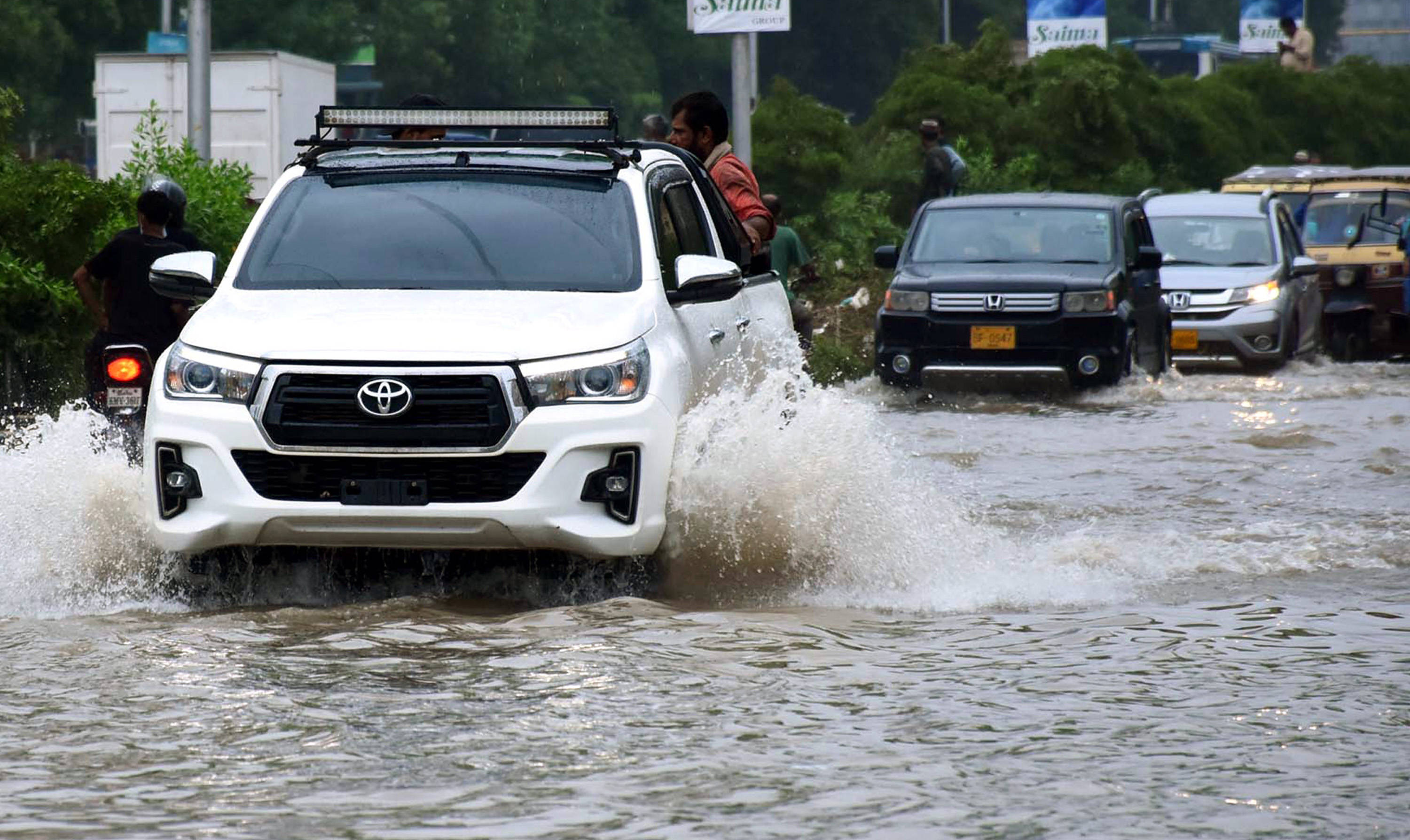 8月27日,汽车在巴基斯坦卡拉奇涉水行驶.