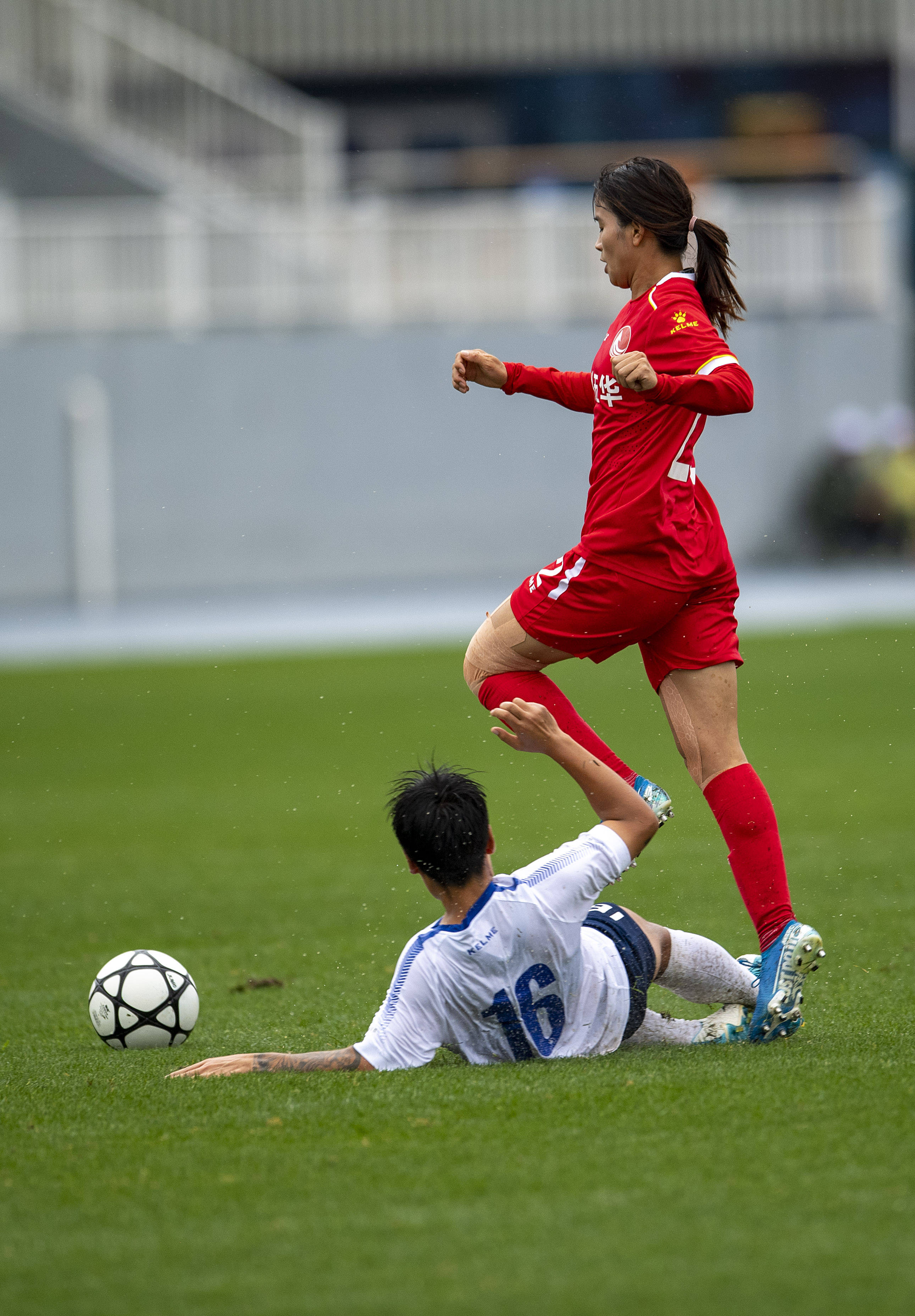 9月12日,广东梅州五华队球员陈巧珠(上)与浙江杭州女足队球员吴慈英在