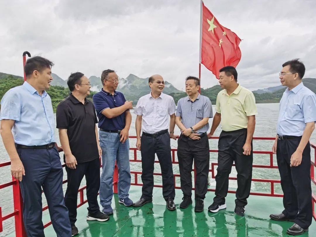 到万峰湖实地调研图为:与会人员参观万峰湖立法工作介绍展板(覃雷)