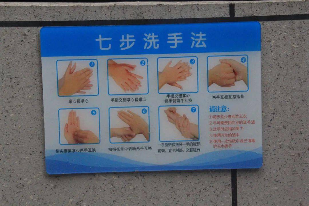 黄州思源实验学校餐厅工作人员规范作业,餐厅洗手处贴有标语