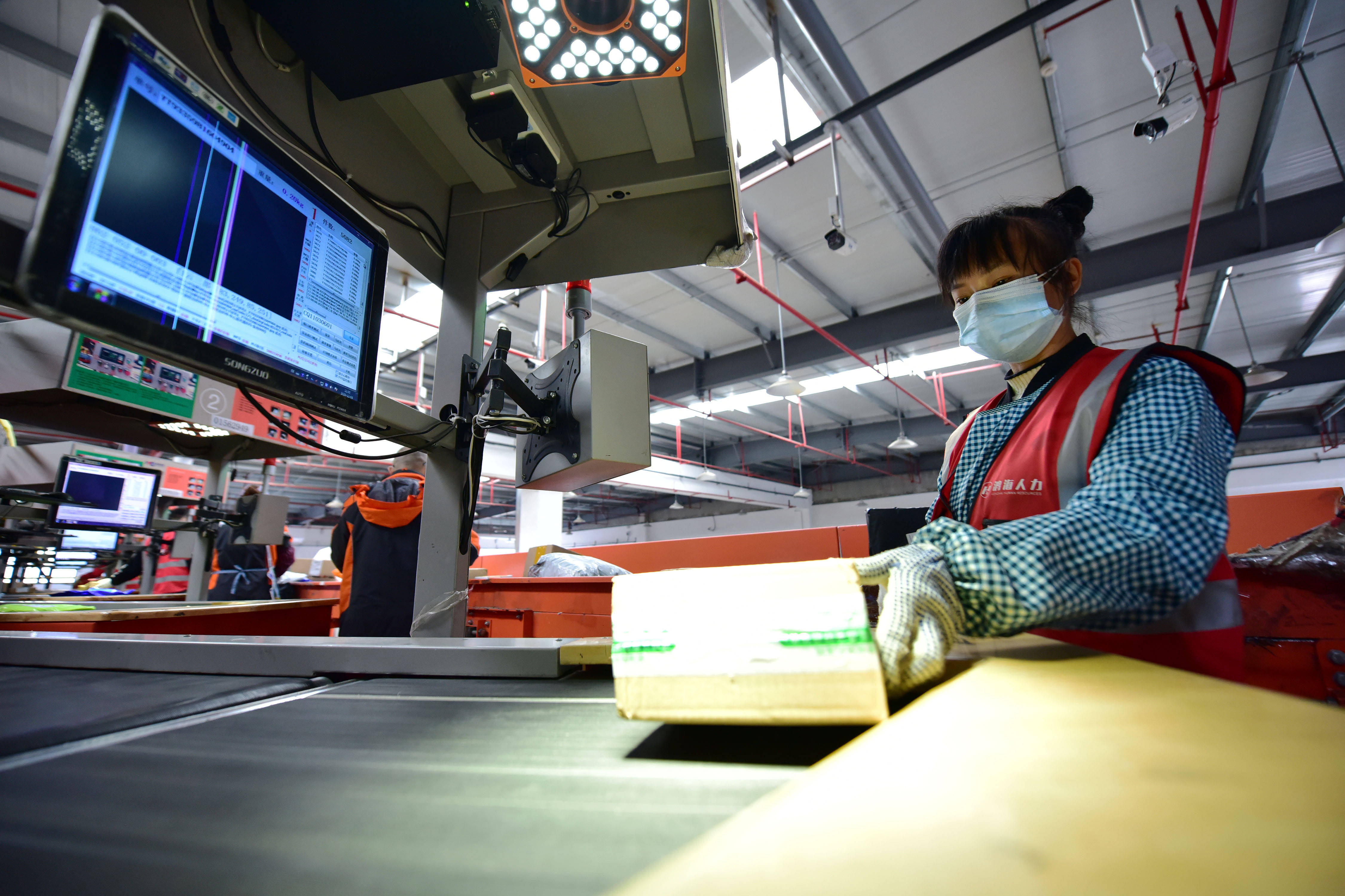 11月3日,在贵州快递物流园一家快递公司,工作人员在扫描分拣快件