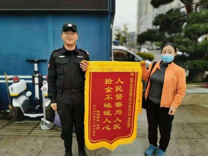 11月17日上午,一名群众手捧"拾金不昧暖人心,人民警察为人民"的锦旗