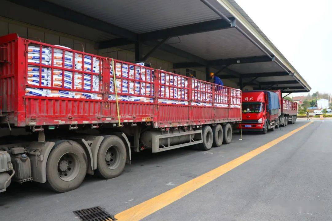 只见柯百微成品库门口停靠了等待装货的两辆重型大货车和1辆中型货车