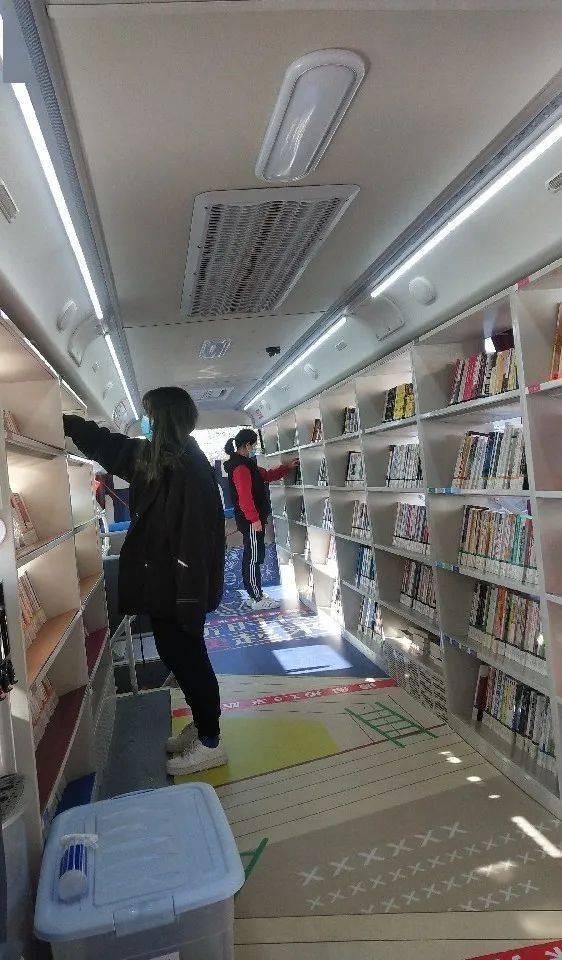 在流动车上借书春华社区居民滨海新区图书馆汽车图书馆流动服务是滨海